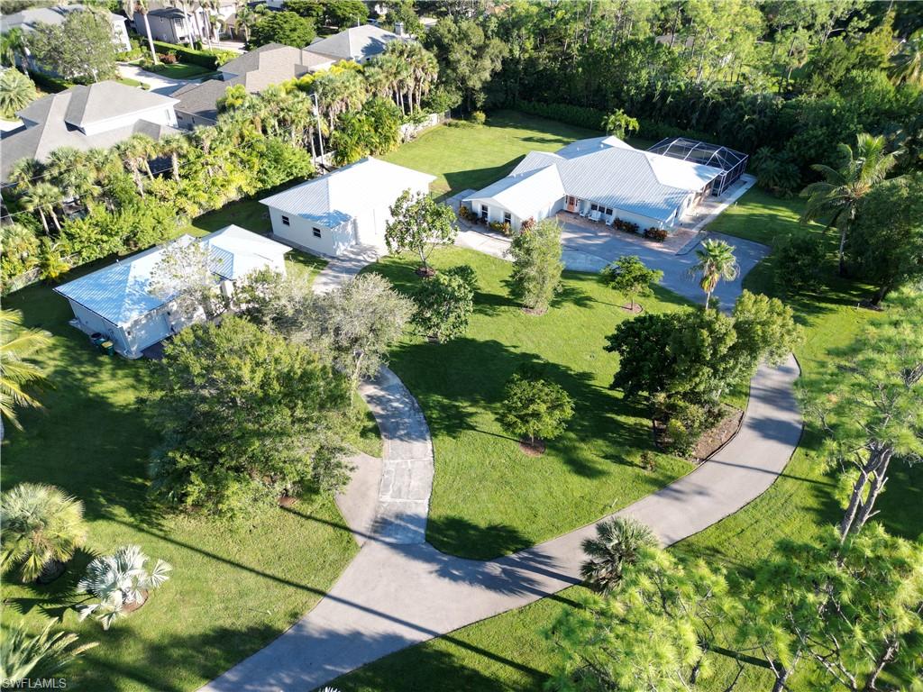 2950 Coach House Lane Naples, FL 34105 - Photo 47 of 50 an aerial view of a house with a yard and lake