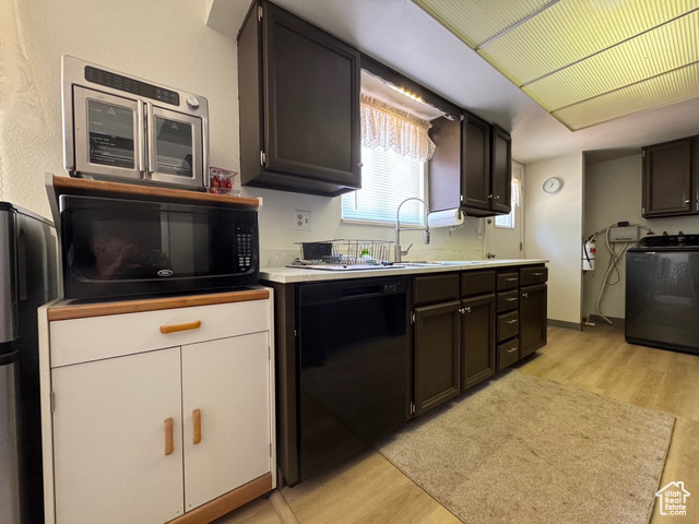 527 Palisade Drive Moab, UT 84532 - Photo 5 of 51 Kitchen with black appliances, washer / dryer, light wood-style flooring, and new ight countertops