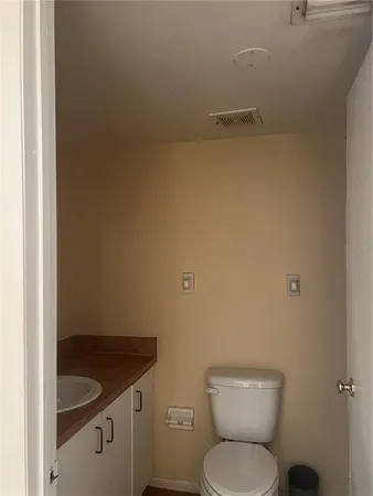 a bathroom with a granite countertop toilet and a sink
