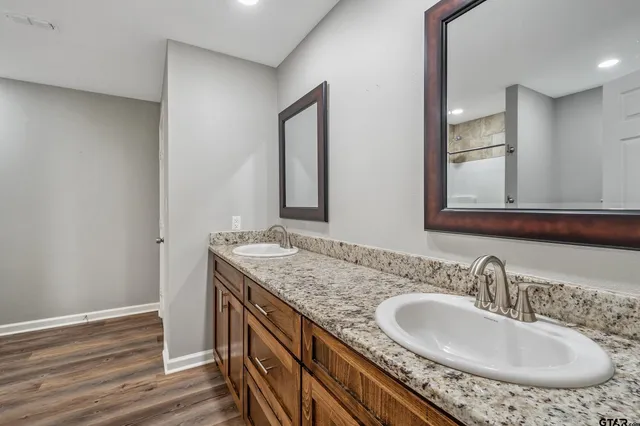 a bathroom with a granite countertop sink and a mirror