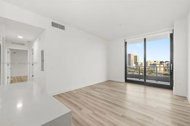 a view of a room with wooden floor and window