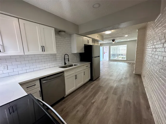 a kitchen with granite countertop a sink appliances cabinets and counter space