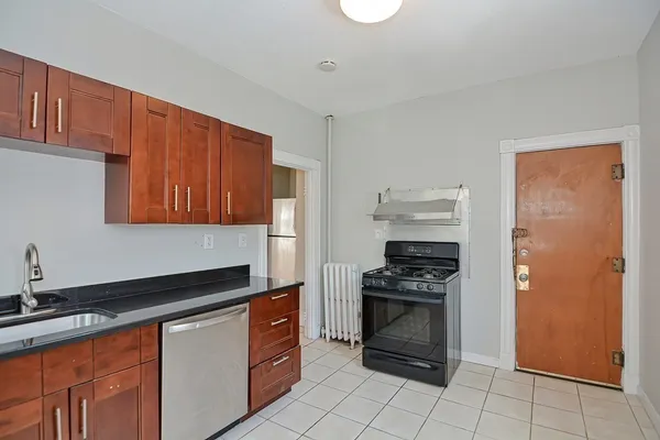 a kitchen with granite countertop a refrigerator and a sink