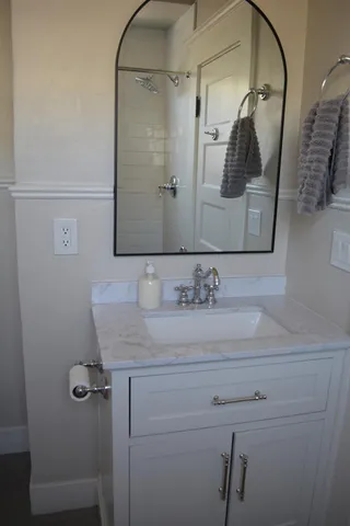 a kitchen with white cabinets and window