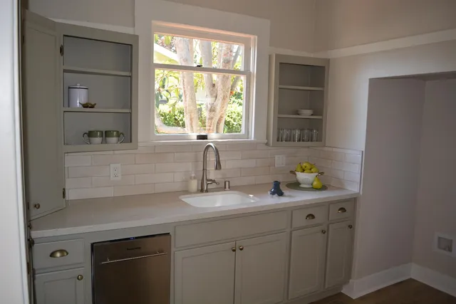 a front view of a house with a tree