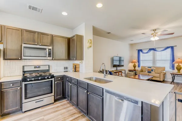 a kitchen with a sink appliances and cabinets