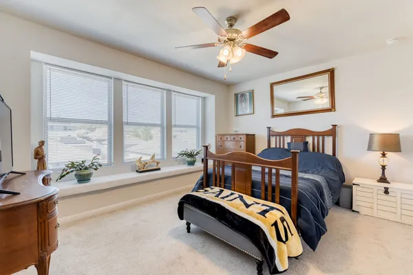 a spacious bedroom with a bed and a large window