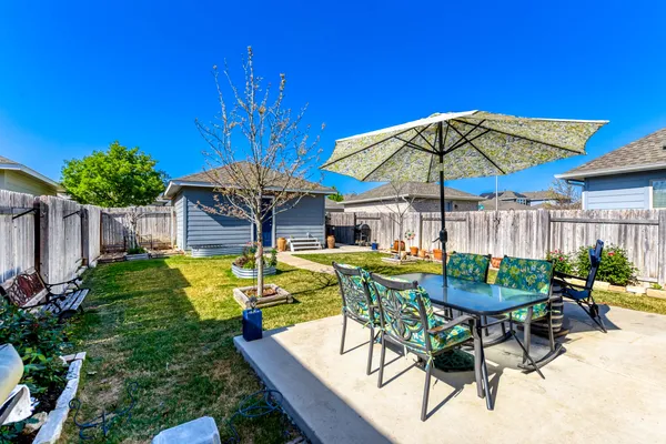 a view of a patio with table and chairs under an umbrella