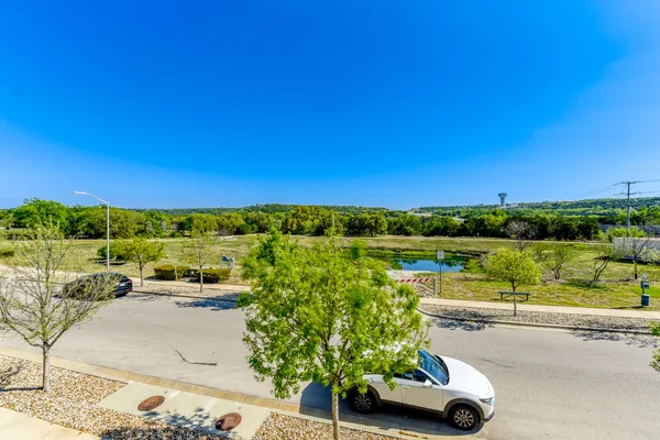 a view of a street with a car parked on the roadside