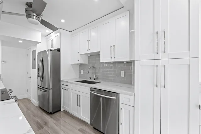a kitchen with a refrigerator sink and cabinets