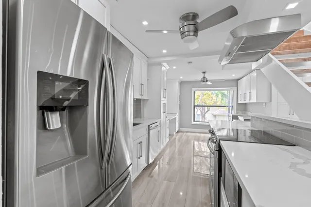 a kitchen with stainless steel appliances granite countertop a refrigerator and a sink