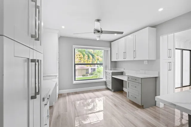 a open kitchen with white cabinets and wooden floor