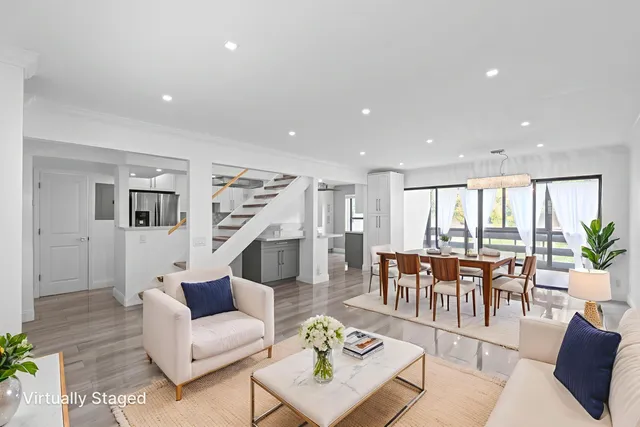 a living room with furniture potted plant kitchen view and a potted plant