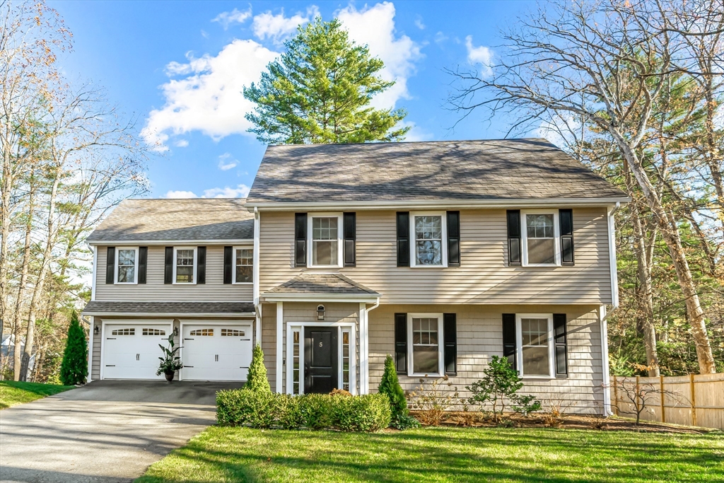 a front view of a house with a garden and trees