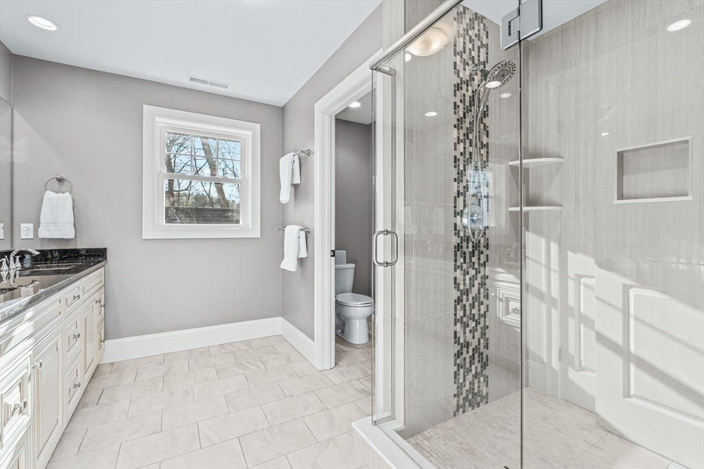 5 Rolling Lane Natick, MA 01760 - Photo 15 of 30 a bathroom with a granite countertop sink a mirror a shower and a vanity