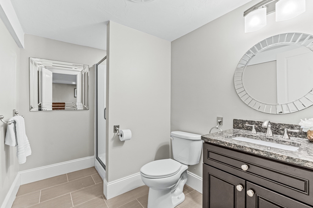 5 Rolling Lane Natick, MA 01760 - Photo 25 of 30 a bathroom with a granite countertop toilet sink and mirror