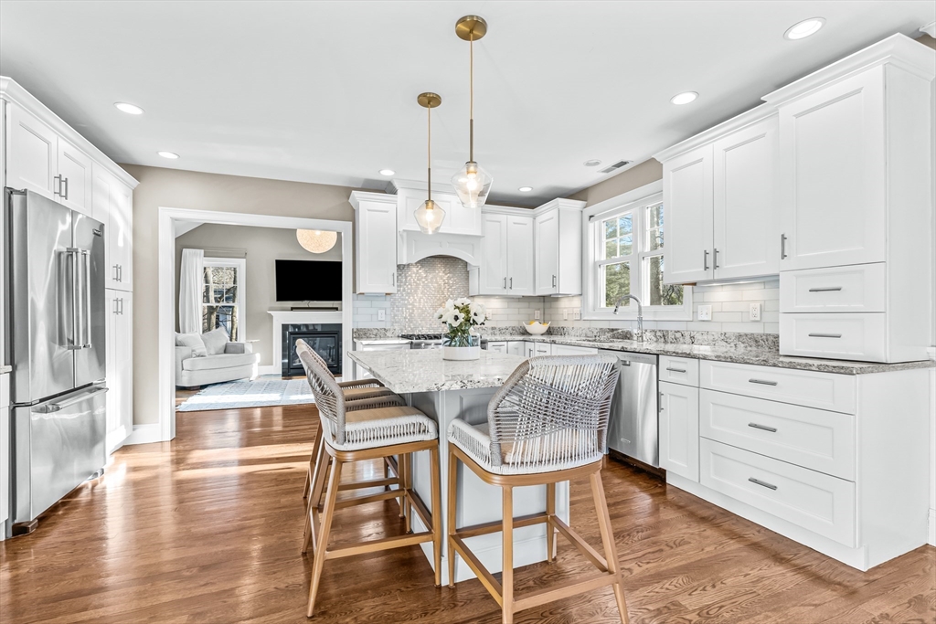 5 Rolling Lane Natick, MA 01760 - Photo 5 of 30 a kitchen with stainless steel appliances kitchen island granite countertop a table chairs and a refrigerator