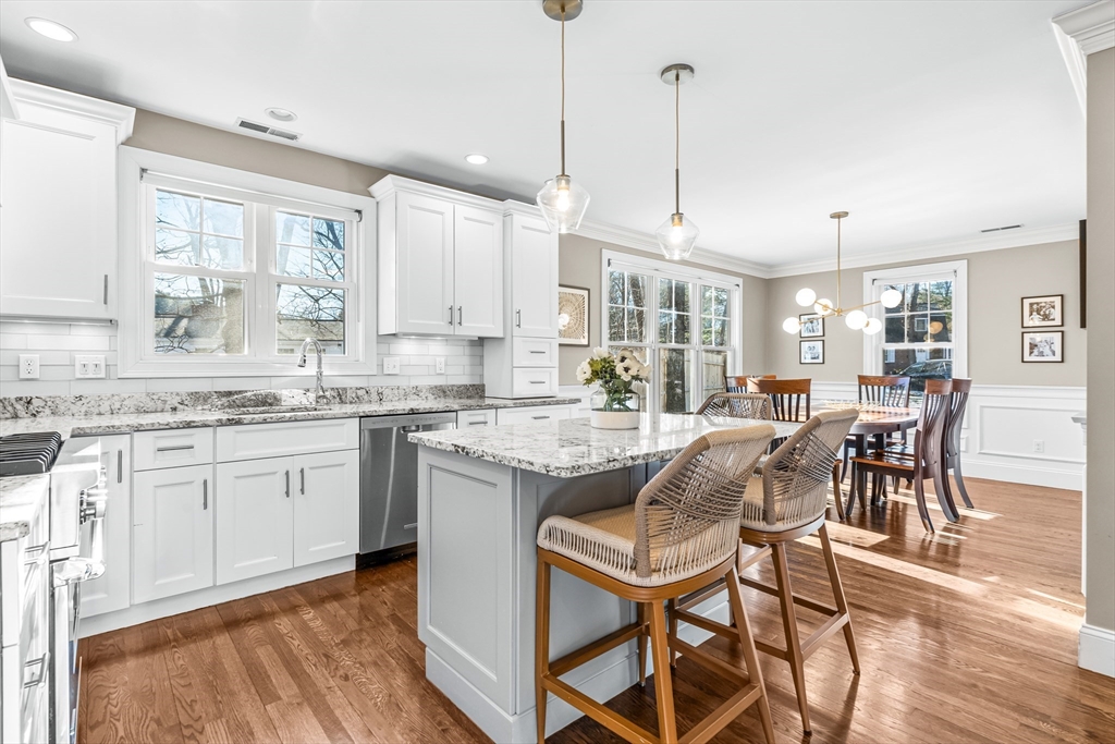 5 Rolling Lane Natick, MA 01760 - Photo 6 of 30 a kitchen with granite countertop kitchen island white cabinets and stainless steel appliances