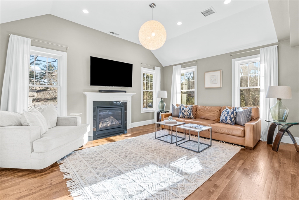 5 Rolling Lane Natick, MA 01760 - Photo 9 of 30 a living room with furniture a flat screen tv and a fireplace