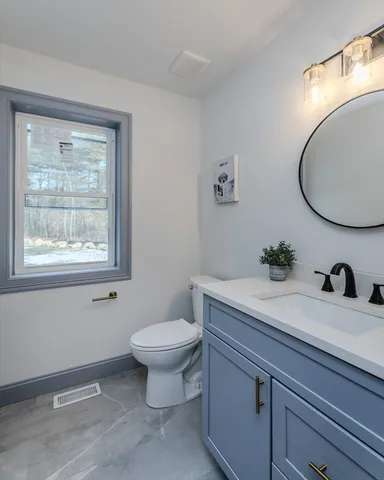 a bathroom with a sink a toilet and a mirror