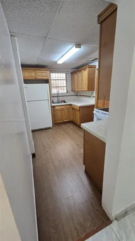 a view of a kitchen with wooden floor and electronic appliances
