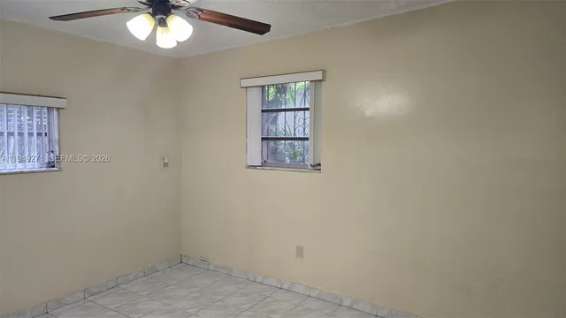 an empty room with a chandelier fan