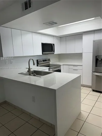 a kitchen with stainless steel appliances a sink a stove and a refrigerator