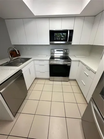 a kitchen with a stove a sink and a cabinets