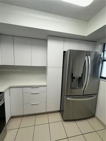 a kitchen with a refrigerator and cabinets