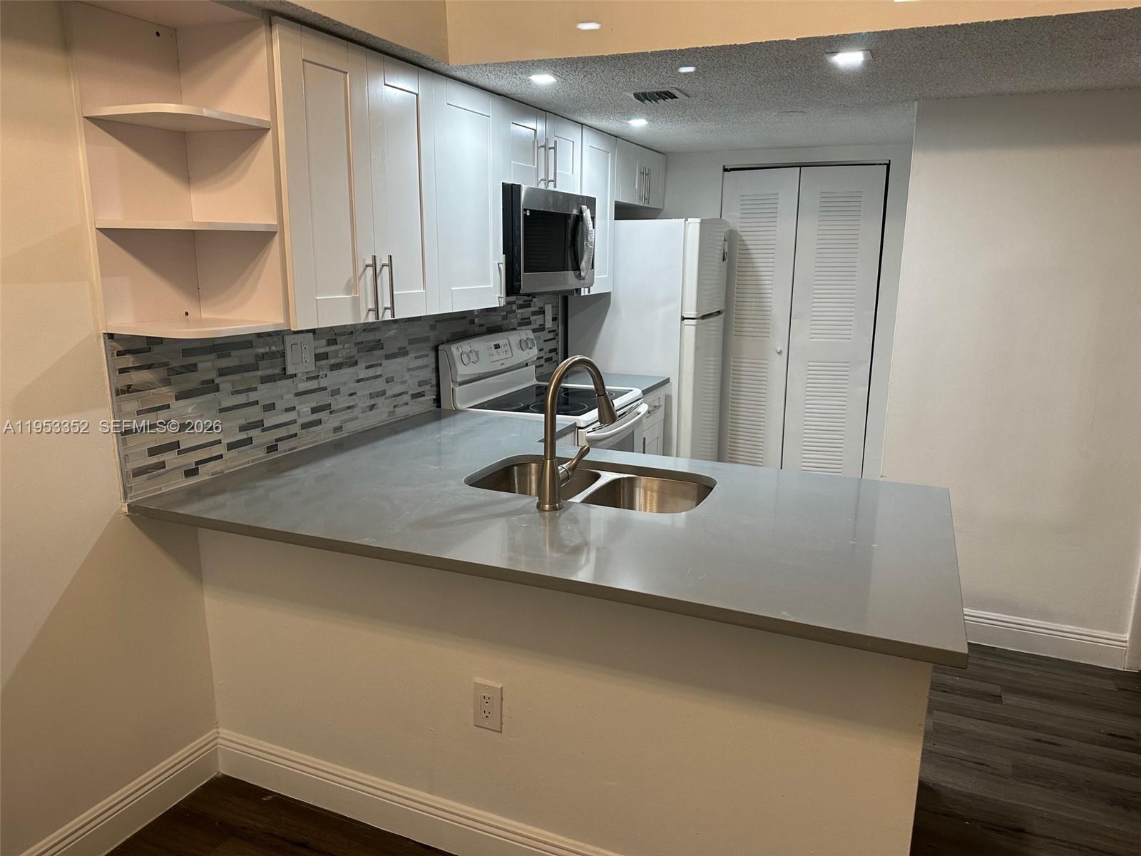 a kitchen with a sink a counter top space cabinets and appliances