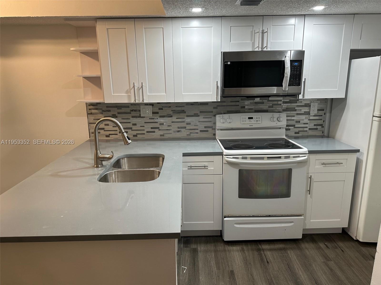 7155 Northwest 179th Street, Unit 304 Hialeah, FL 33015 - Photo 3 of 14 a kitchen with a stove and a microwave