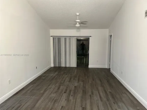 an empty room with wooden floor and chandelier