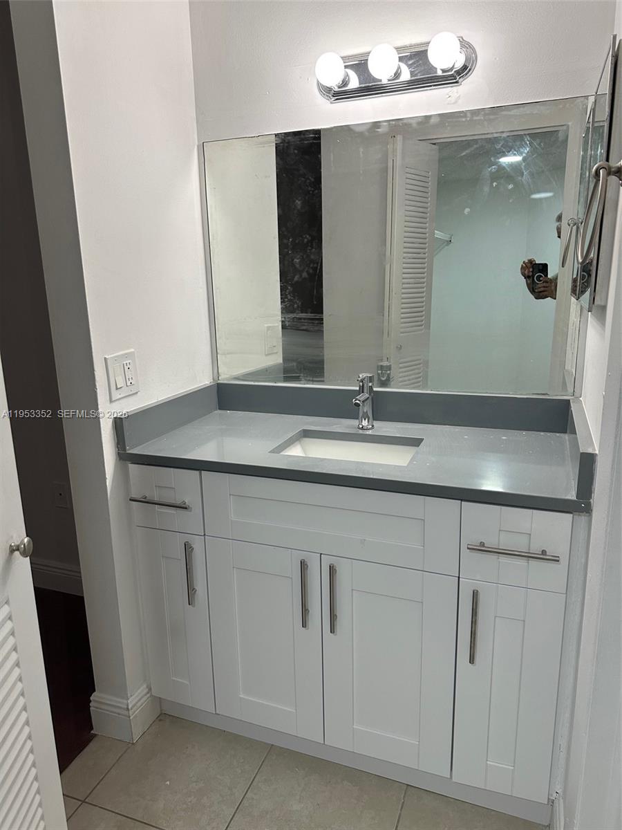 7155 Northwest 179th Street, Unit 304 Hialeah, FL 33015 - Photo 8 of 14 a bathroom with a sink and a mirror