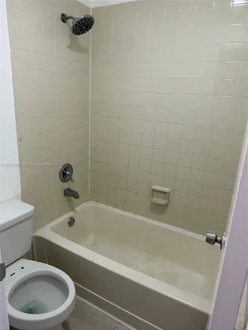 a white bath tub sitting next to a toilet