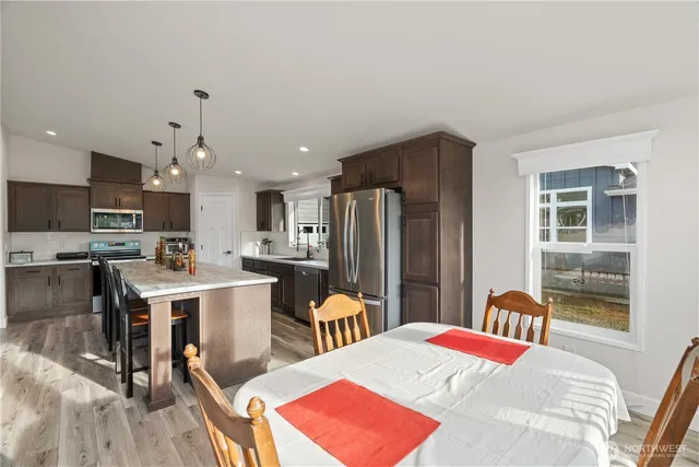 a kitchen with stainless steel appliances kitchen island granite countertop a refrigerator and a stove top oven