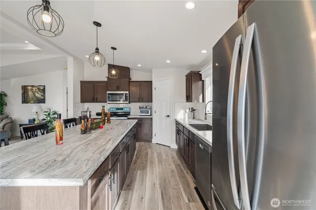 a kitchen with stainless steel appliances granite countertop a sink refrigerator and microwave