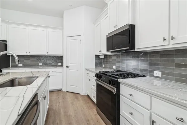 a kitchen with granite countertop a stove and a sink
