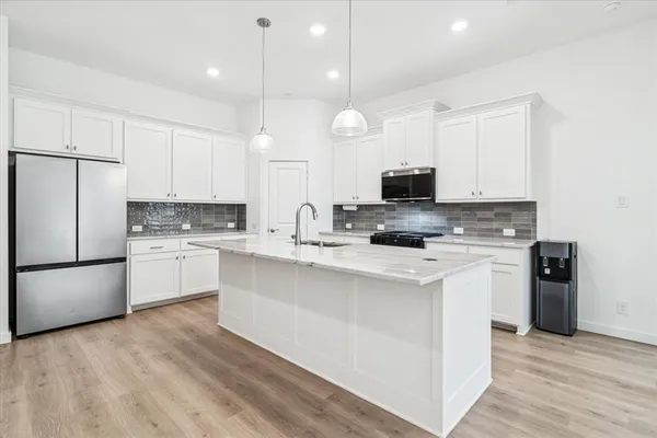 a kitchen with stainless steel appliances a stove a sink and a refrigerator