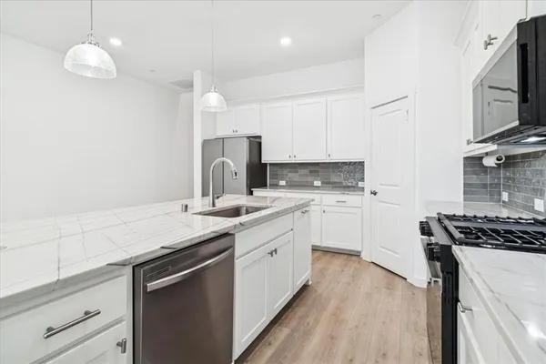 a kitchen with white cabinets stainless steel appliances and sink