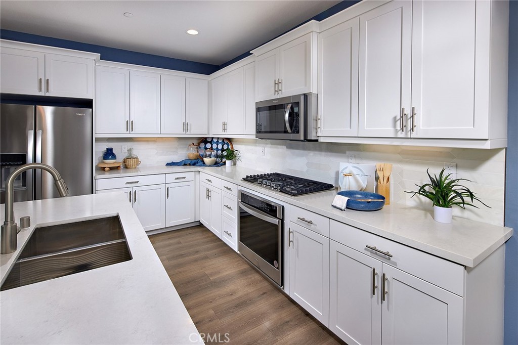 29614 Saddle Drive Winchester, CA 92596 - Photo 3 of 12 a kitchen with white cabinets and white appliances