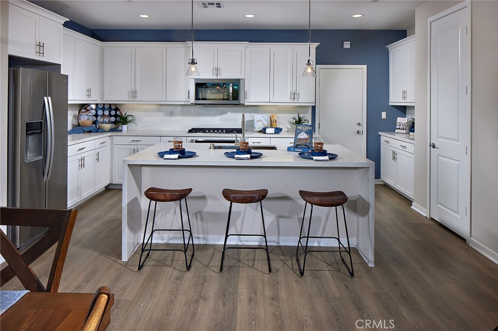 29614 Saddle Drive Winchester, CA 92596 - Photo 6 of 12 a kitchen with stainless steel appliances a table chairs refrigerator and a microwave