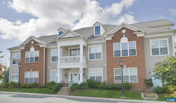 a front view of a residential apartment building with a yard