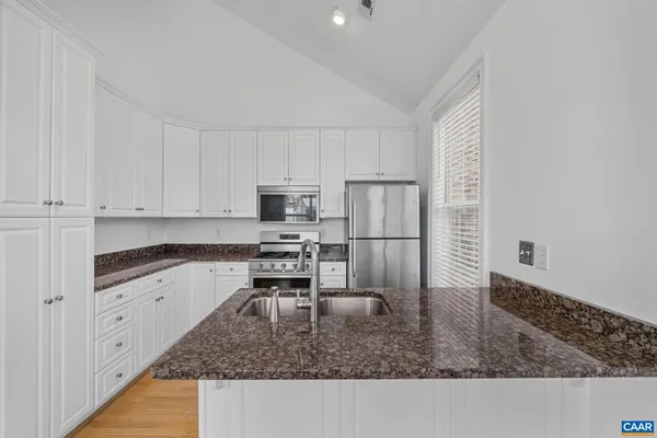 a kitchen with stainless steel appliances granite countertop a sink stove and refrigerator