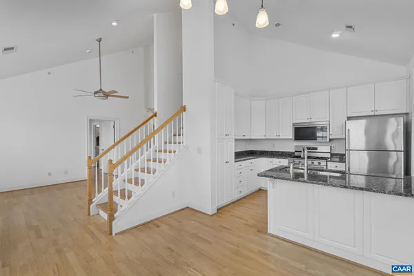 a kitchen with stainless steel appliances granite countertop a sink a stove a microwave and cabinets