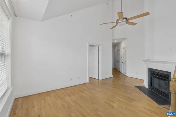 a view of empty room with wooden floor and fireplace
