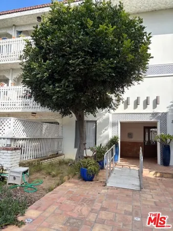 a view of house with outdoor seating and plants
