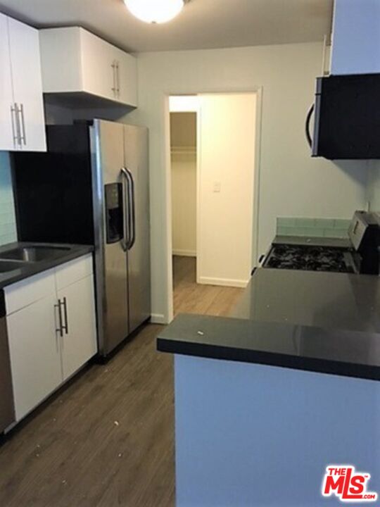 3111 4th Street, Unit 215 Santa Monica, CA 90405 - Photo 7 of 12 a view of a kitchen with stainless steel appliances granite countertop a refrigerator and a stove