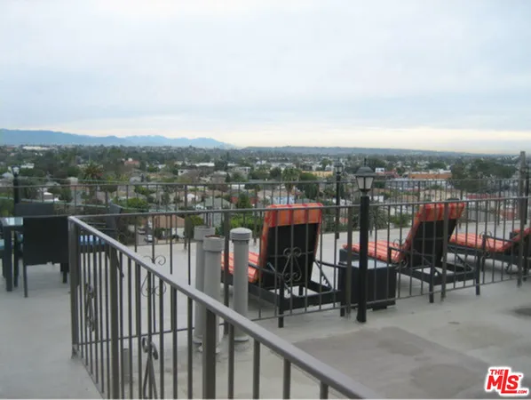 a balcony with wooden floor and city view