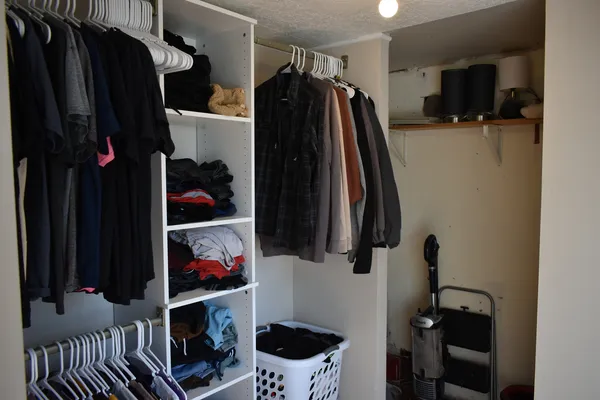a view of walk in closet with clothes and shoes