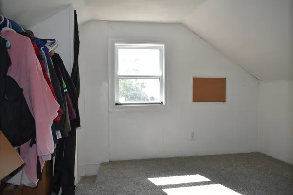 a bed sitting in a bedroom next to a window